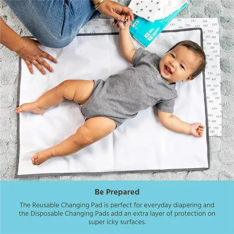 Extra-large grey baby changing pad with a smiling baby in a onesie, surrounded by changing supplies and soft surface.