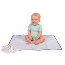 Extra-large grey baby changing pad with a smiling baby sitting on it, alongside three patterned cloths.