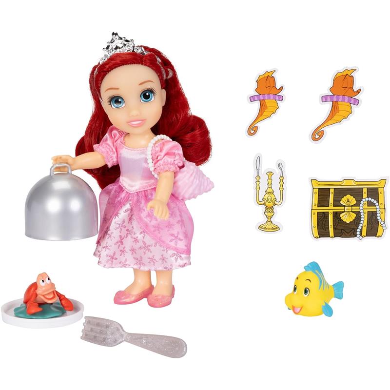 Ariel doll in a pink dress holding a silver cloche, with accessories including a crab, fork, and decorative items.