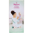 A child with curly hair holds the Jakks Rapunzel doll, dressed in a purple gown, sitting in a living room.