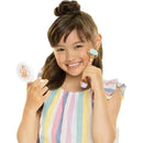 Young girl with long hair holds a mirror and a facial roller, wearing a colorful striped top and smiling.