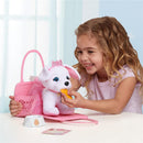 A girl plays with a white plush puppy wearing a crown, feeding it a treat while seated at a table with a pink tote.