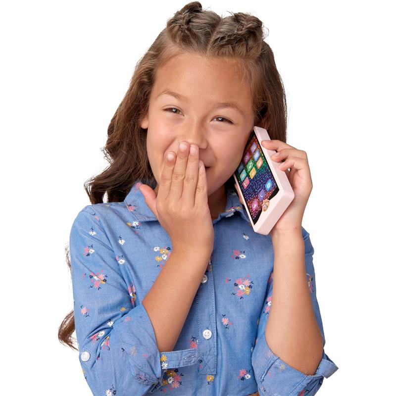Young girl with braided hair playfully holds a pink toy phone to her ear, smiling with her hand covering her mouth.