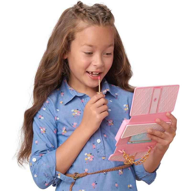 A girl with long hair holds a pink wristlet phone, smiling and holding a lollipop, dressed in a floral blue shirt.
