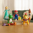5-inch action figures of Mario, Rosalina, Yoshi, Bowser, and a yellow glow-in-the-dark Luma Star on stacked books.
