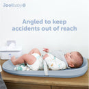 Premium blue changing pad with a baby wearing a bib, angled to prevent accidents, placed on a wooden surface with a wipe dispenser nearby.