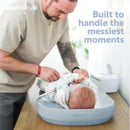 Premium blue Jool Baby changing pad with a caregiver tending to an infant, highlighting its function for messiest moments.