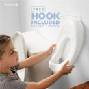 Toilet training seat in white being held by a child, with a free hook for easy storage visible on a wall.