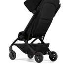 Lightweight compact stroller in Space Black, featuring a sleek design, adjustable seat, and star-patterned wheels.
