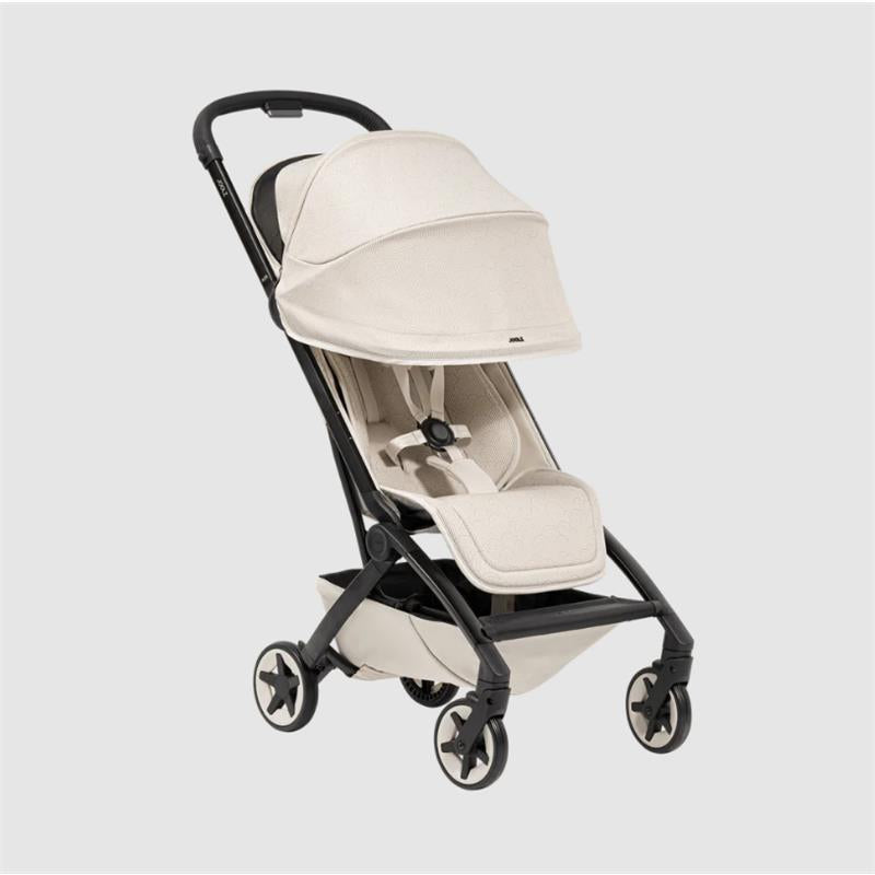Lightweight compact stroller in calming beige with a foldable canopy, adjustable harness, and four wheels for easy maneuverability.