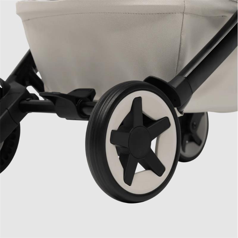 Compact Joolz Aer² stroller in calming beige, showing its black and white star-design wheels and lightweight frame.