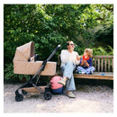 Joolz Aer2 Fold Cot in Chic Renaissance design beside a father and children playing with bubbles on a bench.
