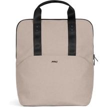Changing backpack in sandy taupe color with black handles, featuring a minimalist design and front zipper pocket.