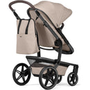 Changing backpack in sandy taupe attached to a stroller, showcasing a minimalist design with dual shoulder straps.