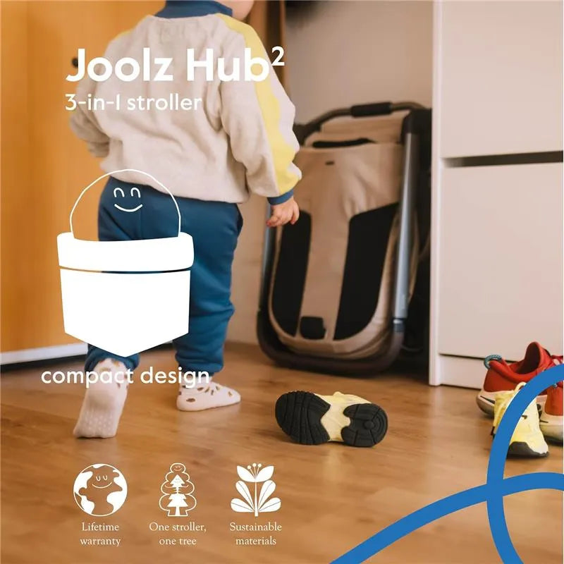 Lightweight Joolz Hub² compact stroller in Forest Green with a child walking nearby, showcasing its compact design features.