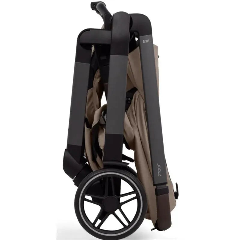 Compact Joolz Hub² stroller in Sandy Taupe, shown folded with sleek black frame and large rear wheel.