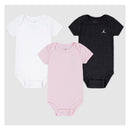 Three baby bodysuits in pink, white, and dark gray, featuring the Jordan logo, suitable for ages 0-6 months.