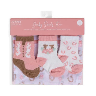 Three pairs of baby socks in a pink and white theme, featuring floral and boot designs, in a reusable mesh wash bag.