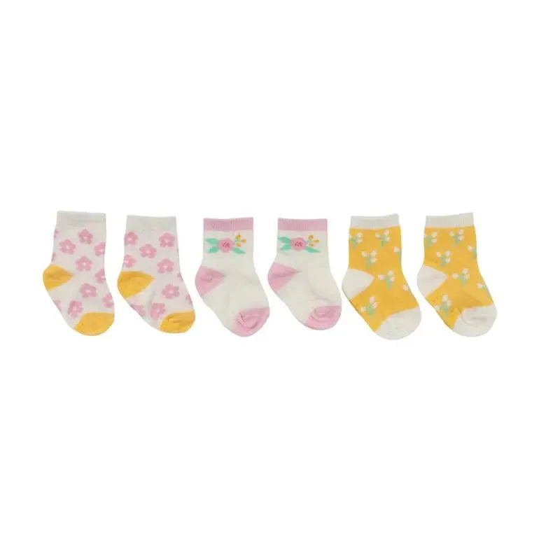 Three pairs of baby socks in pastel colors: pink with flowers, white with floral design, and yellow with daisies.