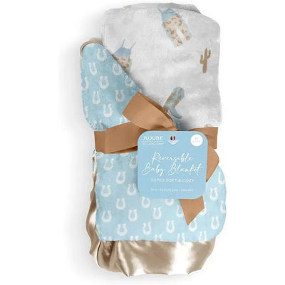 Reversible baby blanket by Jujube in Howdy Partner Blue, featuring a blue side with horseshoes and a white side with cacti and cowboys.
