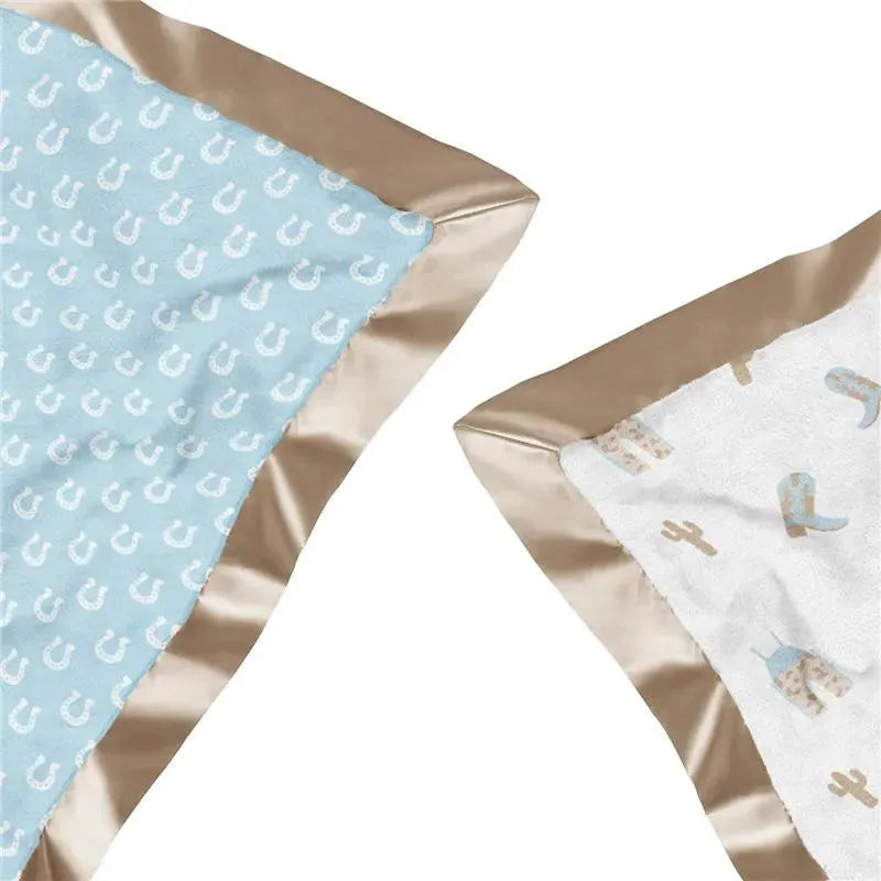 Reversible baby blanket featuring a blue side with white horseshoe patterns and a soft white side with cowboy boots and cacti designs, edged in tan satin.