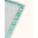 Reversible baby blanket with a soft white surface featuring a delicate floral pattern and a mint green satin border.