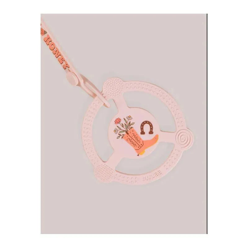 Silicone teether ring in pink with a detachable clip, featuring floral designs and a playful boot illustration.
