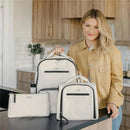 Insulated bottle bag and two other bags from Jujube x Witney Carson, displayed by a smiling woman in a kitchen setting.