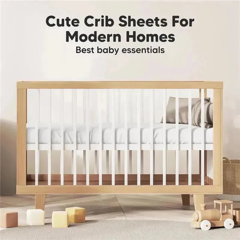 Organic cotton fitted crib sheets in soft white displayed in a modern crib, with toys and neutral decor in the background.
