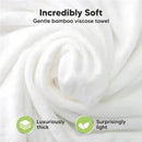 Incredibly soft, white bamboo viscose towel shown in a rolled-up position, highlighting its luxurious thickness and lightweight nature.