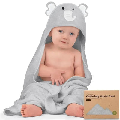 Baby in a gray elephant hooded towel, sitting with a playful expression; towel is soft and fluffy, packaging visible beside.