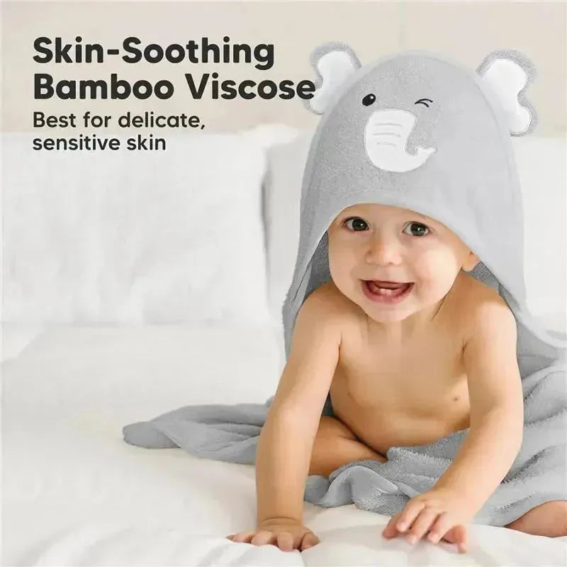 Hooded elephant towel draped on a smiling baby, highlighting soft bamboo viscose for sensitive skin.
