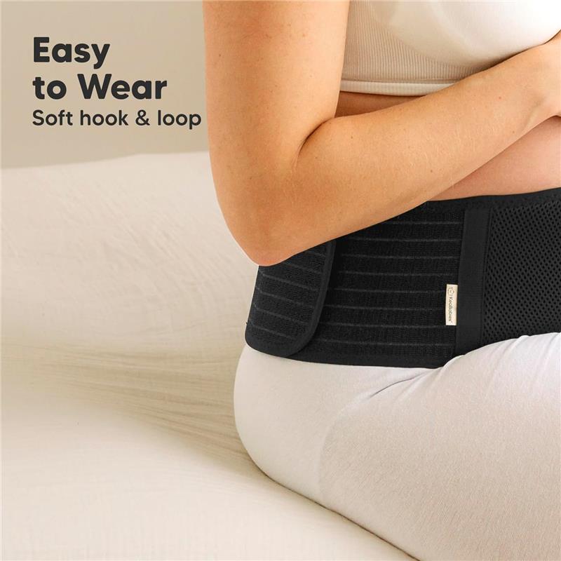 Maternity belly band in black worn by a pregnant woman, featuring soft hook and loop design for easy wearing.