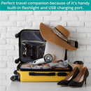 Yellow suitcase packed with clothing, a sunhat, sunglasses, a fan, a laptop, and a coffee cup against a white brick wall.