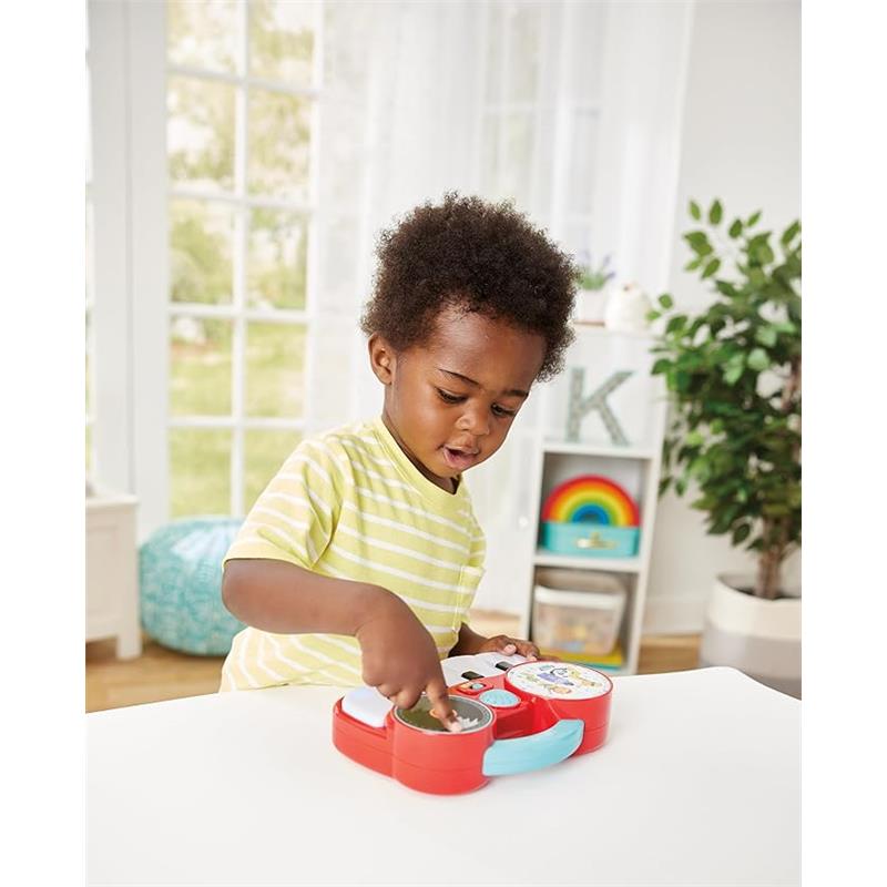 Child playing with Kidoozie My First DJ Piano, featuring colorful buttons and music features, in a bright indoor setting.