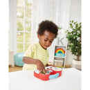 Child playing with Kidoozie My First DJ Piano, featuring colorful buttons and music features, in a bright indoor setting.