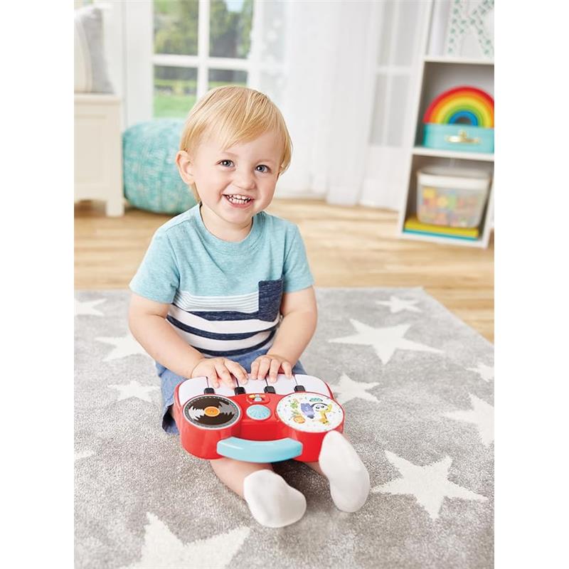 Toddler sitting on a carpet playing with the Kidoozie My First DJ Piano, smiling and enjoying the colorful toy.