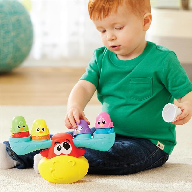 Child stacking colorful animal-shaped pieces on a Wobbly Stacking Moose toy, encouraging fine motor skills and play.