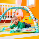 Infant playing on the Bright Starts Wild Wiggles Activity Gym, featuring colorful arch, soft mat, and attached toys.
