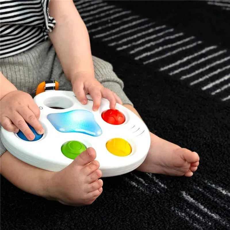 Colorful sensory toy with buttons, held by a child, promoting tactile engagement and visual stimulation.