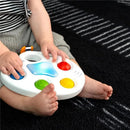 Colorful sensory toy with buttons, held by a child, promoting tactile engagement and visual stimulation.