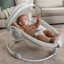 Baby seated in the Ingenuity InLighten Bouncer, interacting with hanging toys in a cozy living room setting.
