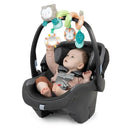 Infant reaching for colorful, plush toys on a spiral activity toy bar attached to a baby car seat.