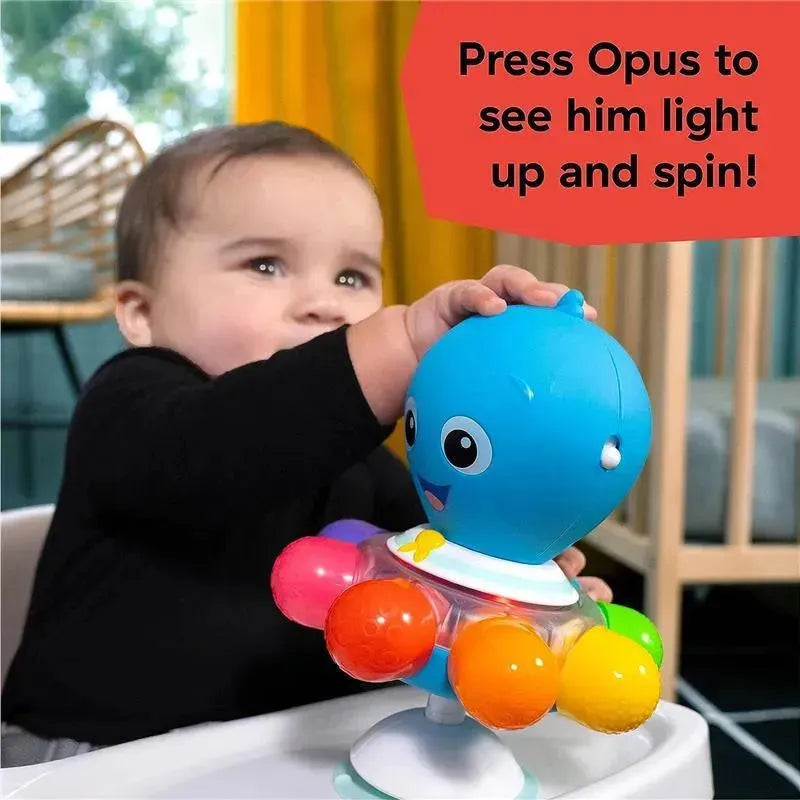 A baby engages with the Kids II Opus’s Spin & Sea Activity Toy, featuring a colorful octopus that lights up and spins when pressed.