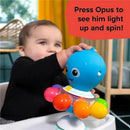 A baby engages with the Kids II Opus’s Spin & Sea Activity Toy, featuring a colorful octopus that lights up and spins when pressed.