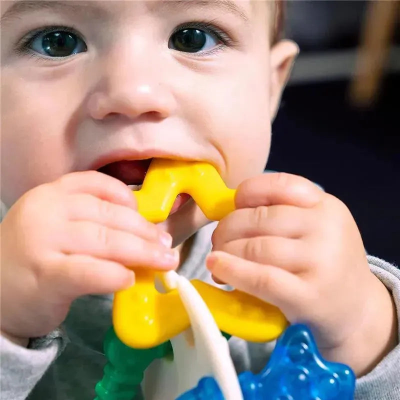 Young child biting a yellow, wavy teether toy, part of the Kids II Sea Of Sensory Teether collection.