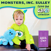 Child wearing a green Sully onesie from Monsters Inc., holding a blue plush character, with product branding visible.