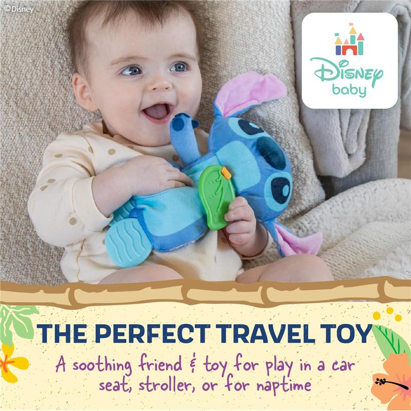 A baby smiles while holding a blue Stitch plush toy with a green teether, designed for soothing and play.