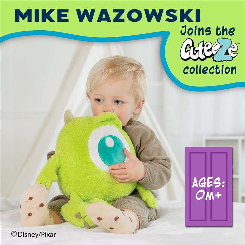 Cute toddler sitting on a bed, hugging a green plush Mike Wazowski toy with a large blue eye, part of the Cuteeze collection.