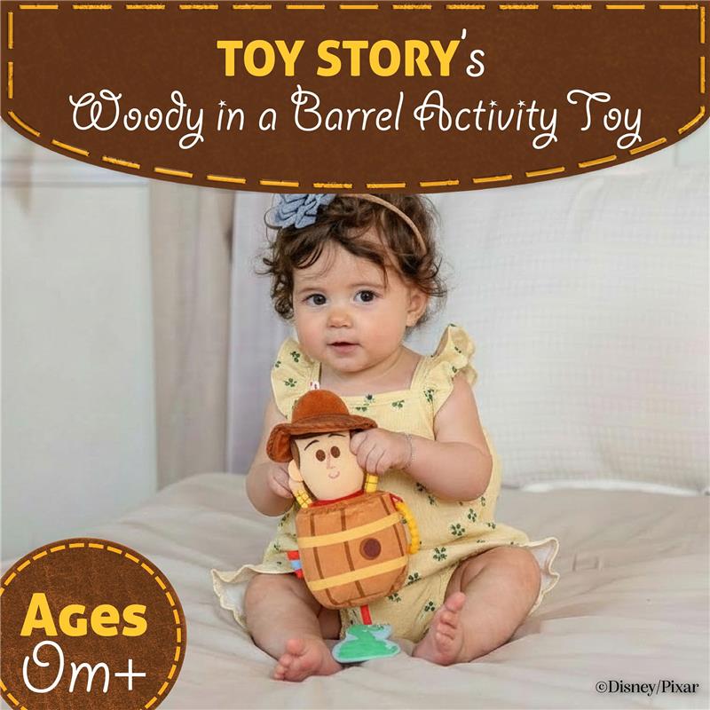 Toddler holding a plush Toy Story Woody in a barrel activity toy, wearing a yellow dress with floral patterns.